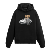 Klasik araba önünde elinde silah tutan takım elbiseli ayıcık baskılı hoodie tasarımı.