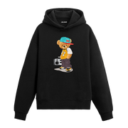 Şapka takan, müzik çaları yanında duran hip-hop tarzında ayıcık figürlü hoodie tasarımı.