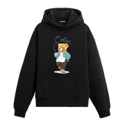 Elinde kahve bardağı tutan, rahat kıyafetler giymiş yürüyen ayıcık baskılı hoodie tasarımı.