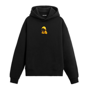 Siyah hoodie üzerinde sarı kapüşonlu gizemli karakter baskısı