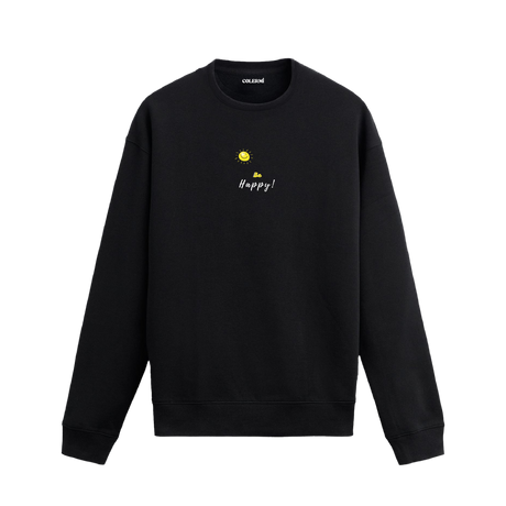 Siyah sweatshirt üzerinde sarı güneş ve altında "Be Happy!" yazısı.