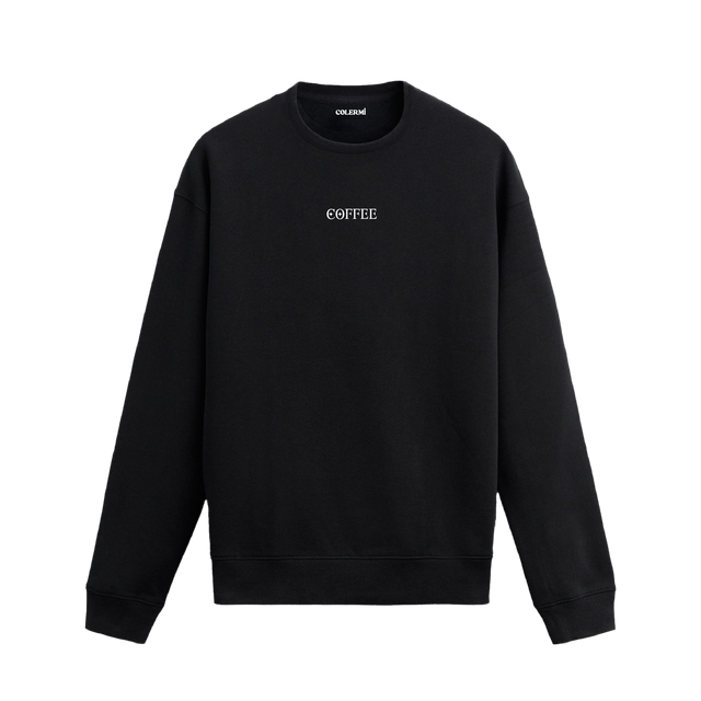 Siyah sweatshirt üzerinde minimal "COFFEE" yazısı detayı.