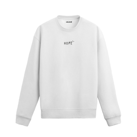beyaz sweatshirt üzerinde göğüs kısmında beyaz "HOPE" yazısı ve üzerinde uçan küçük kuş figürleri bulunan minimal tasarım.