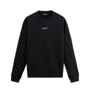 Siyah sweatshirt üzerinde göğüs kısmında beyaz "HOPE" yazısı ve üzerinde uçan küçük kuş figürleri bulunan minimal tasarım.