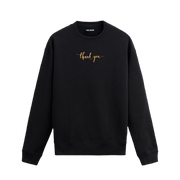 Siyah sweatshirt üzerinde göğüs kısmında altın tonlarında yazılmış “thank you” ifadesi bulunan minimal tasarım.