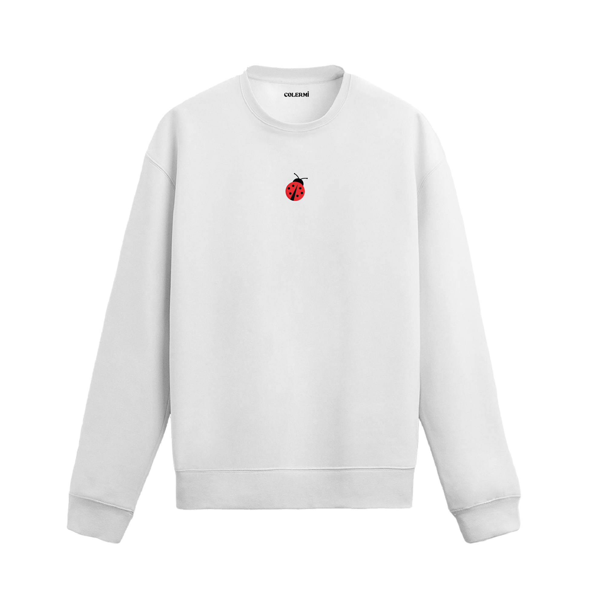 Beyaz sweatshirt üzerinde göğüs kısmında kırmızı küçük uğur böceği baskısı bulunan minimal tasarım.
