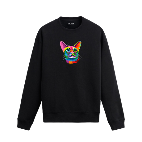 Siyah sweatshirt üzerinde öne bakan renkli kedi tasarımı.