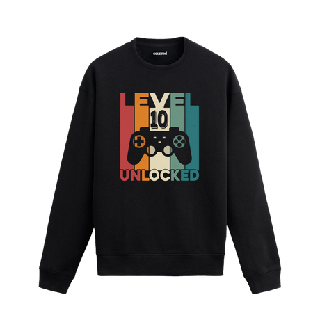 Retro renk blokları üzerinde oyun konsolu ve “Seviye 10 Açıldı” yazılı siyah sweatshirt.