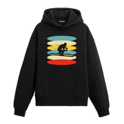 Kayak yapan figür baskılı siyah hoodie – retro renk geçişli kış temalı tasarım