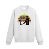 Uzay temalı beyaz sweatshirt üzerinde uzaylı ve kocaayak figürlerinin el sıkıştığı, arkada UFO ve retro güneş tasarımı bulunan yaratıcı illüstrasyon.