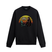 Uzay temalı siyah sweatshirt üzerinde uzaylı ve kocaayak figürlerinin el sıkıştığı, arkada UFO ve retro güneş tasarımı bulunan yaratıcı illüstrasyon.